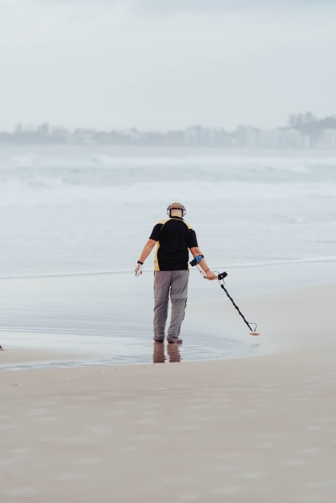 a man standing on top of a sandy beach next to the ocean