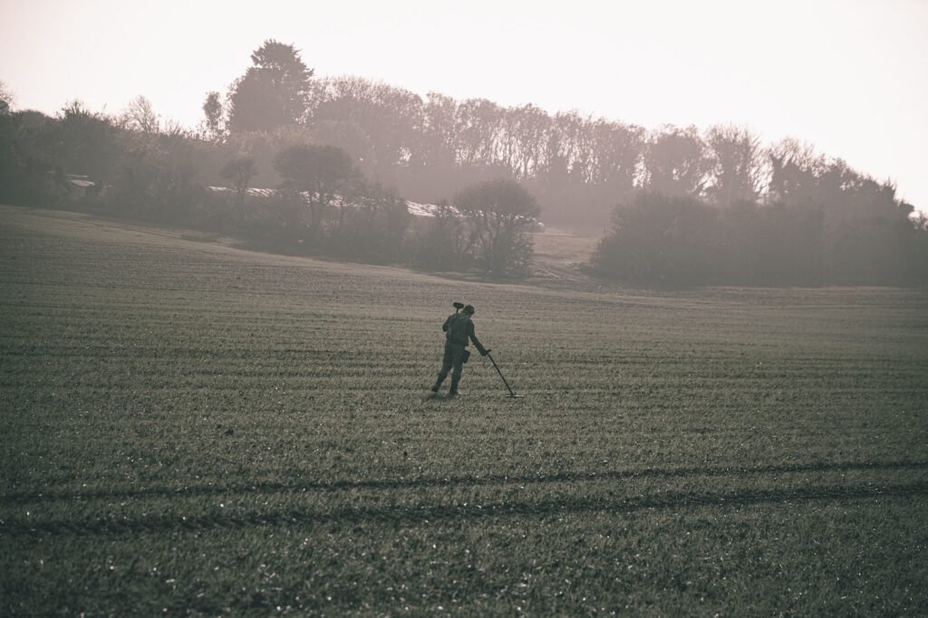 man in black jacket walking on green grass field during daytime